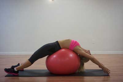 Demonstrating back-bend on ball for pain relief
